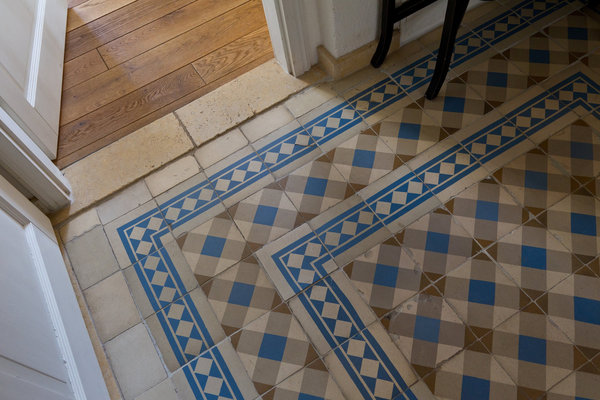 Déniché chez un récupérateur autrichien, le carrelage de l’entrée forme un élégant dessin bordé d’une frise, donnant l'impression que le sol a toujours été là.