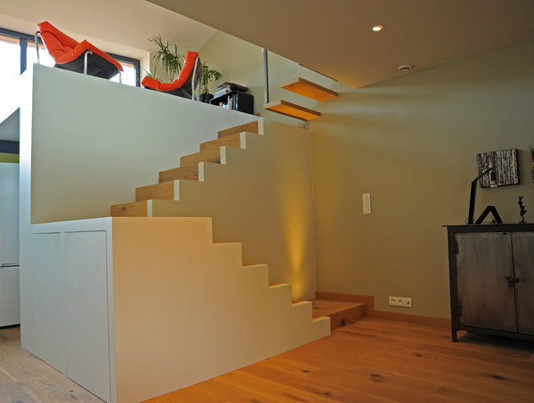 Monté sur une estrade, un podium réalisé en ossature bois recouverte de plaques de plâtre et de parquet accueille un petit coin détente lumineux.