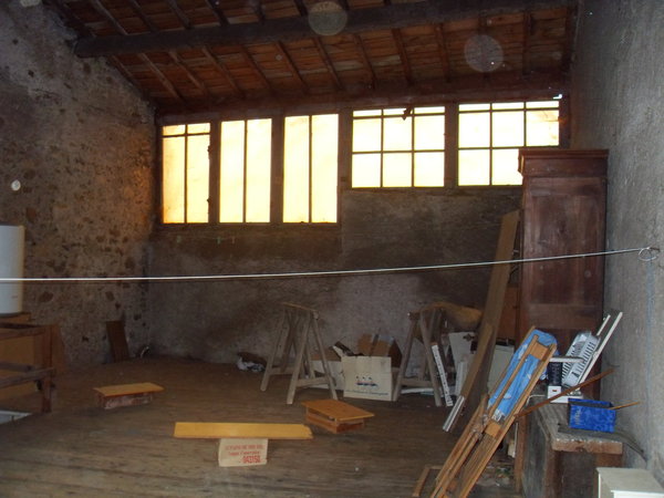 L’atelier avant travaux avec son ancienne baie vitrée existante au dessin hétéroclite.
