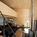 Derrière le poêle à bois, un panneau en terre cuite permet de régler l’hygrométrie du logement, en absorbant ou en dégageant de l’humidité, en fonction des besoins.