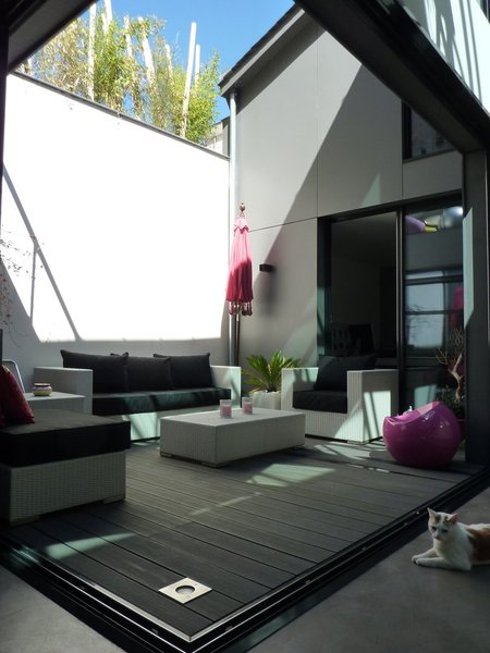 La terrasse extérieure est recouverte de lames composites de bois et ciment.