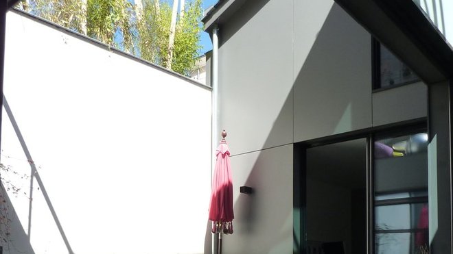 La terrasse extérieure est recouverte de lames composites de bois et ciment.