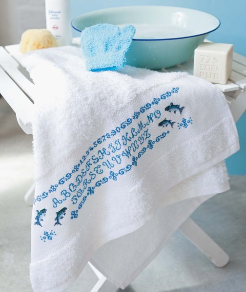 O comme océan, des poissons, un alphabet, des chiffres qui courent à l'intérieur d'une frise sur l'étamine d'une serviette à broder.