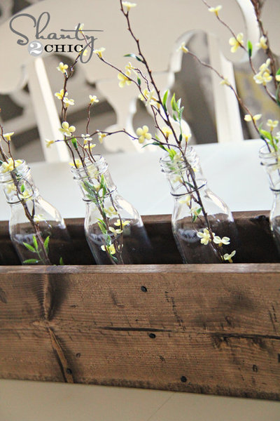 Des bouteilles de même taille s'installent dans la boîte pour y accueillir au fil des saisons, fleurs et branches.