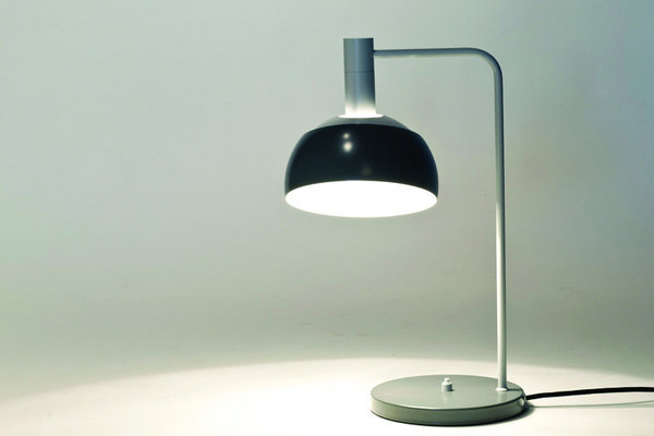 Appartenant à une série de lampes conçue en 1963, ce luminaire est un modèle rare et très convoité pour sa forme moderne. En métal laqué, l’abat jour s’incline pour orienter la lumière selon les envies, dans un respect du mouvement cher à Finn Juhl.