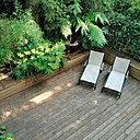 Les bains de soleil beiges, installés dans un angle de la terrasse en bois, sont entourés de végétation. L'impression d'évasion est totale !