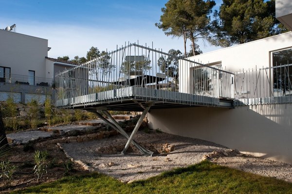 La terrasse en bois lamellé est surélevée, pour offrir un regard plongeant sur les eaux bleues de la piscine.