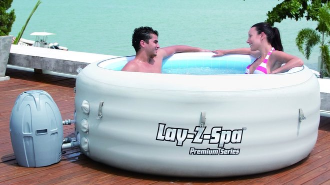 Ce spa gonflable Bestway, tout en rondeur, mesure 61centimètres de profondeur, et 196 de diamètre. Le chauffe-eau est posé à côté, à gauche.