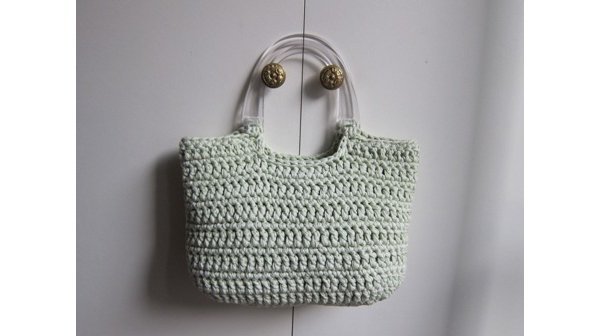 Ce panier, modèle "Pomme", voit sa couleur unie et douce modernisée par des anses transparentes et rigides.