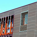 La façade est entièrement constituée de terre cuite, qui joue sur un effet de contrastes entre l’ébène et le rouge-orangé. Le rythme de la construction est accentué par le jeu des formes, entre les brise-soleil et les arrêtes horizontales du bardage.