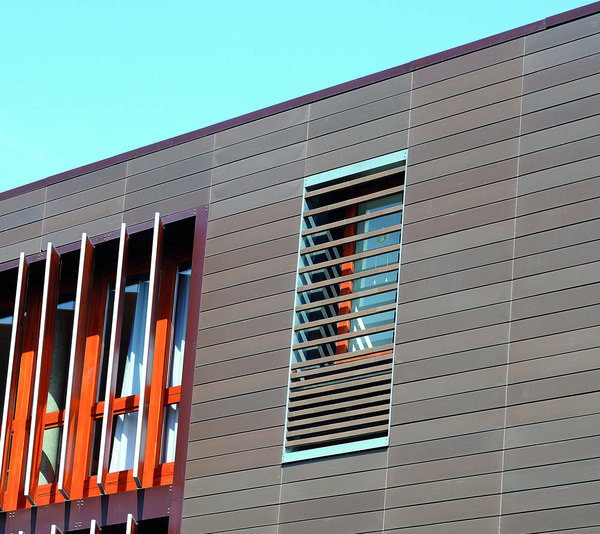 La façade est entièrement constituée de terre cuite, qui joue sur un effet de contrastes entre l’ébène et le rouge-orangé. Le rythme de la construction est accentué par le jeu des formes, entre les brise-soleil et les arrêtes horizontales du bardage.