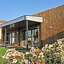 La maison est recouverte d’un bardage bois ajouré qui s’ajoute aux enduits extérieurs organiques bi-ton, de l’autre côté du bâtiment. La maison est recouverte d’un bardage bois ajouré qui s’ajoute aux enduits extérieurs organiques bi-ton, de l’autre côté du bâtiment.