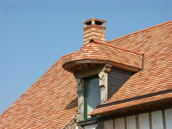 Toit  à l'ancienne recouvert de tuiles de teintes panachées.