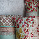 Collection Lady Flower, coussins longs mélangeant tissus fleuris, aux galons et soieries.