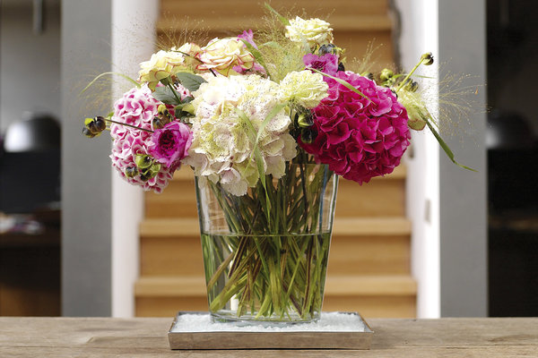 Un bouquet de fleurs d'hortensia habille le centre de la table, pour une atmosphère chaleureuse et gaie.