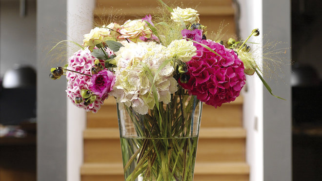 Un bouquet de fleurs d'hortensia habille le centre de la table, pour une atmosphère chaleureuse et gaie.