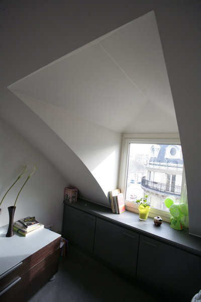 Tous les aménagements ont été prévus en rapport avec les différentes hauteurs sous plafond qui vont de 2,45 m à environ 0,60 cm en soupente sous les ouvertures. Mitoyen de la chambre, le coin toilettes est cloisonné par une porte pliante en accordéon. Sur mesure, comme celle de la chambre, elle est biseautée en hauteur pour épouser la pente du toit.