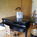 Dans le salon, un grand piano à queue répond aux coloris clairs des murs de briques blanchie ou plaqués de bouleau naturel.