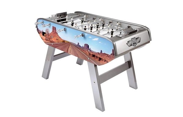 Dans une déclinaison du modèle B90, Bonzini propose un babyfoot, dont l’impression évoque le grand Ouest Américain, grâce à une composition réalisée en film numérique alors que la structure est laquée en gris métallisé.