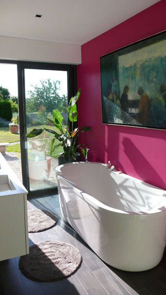 La salle de bains, comme une pièce à vivre, s’ouvre sur le jardin et fait la part belle à la couleur et à la lumière.
