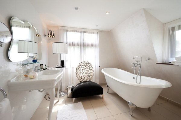 L’esprit boudoir prend place dans cette salle de bains, dont la baignoire et le grand lavabo rétro proviennent de chez Devon & Devon.