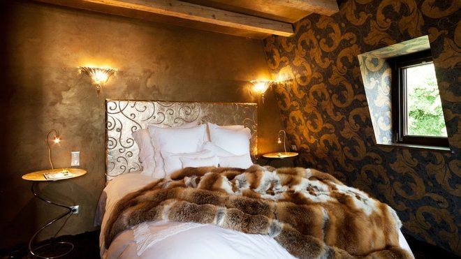 Surplombé par un dessus-de-lit en acajou et soie, un plaid de véritable renard argenté est jeté avec désinvolture sur le lit, comme une invitation voluptueuse. Moquette Stepevi.