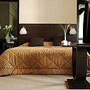 Sur des tonalités de bruns, le décor se fait très vintage, avec son double lits, ses lampes Knoll, ses tapis signés BIC en laine blanche.