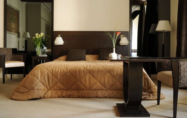 Sur des tonalités de bruns, le décor se fait très vintage, avec son double lits, ses lampes Knoll, ses tapis signés BIC en laine blanche.