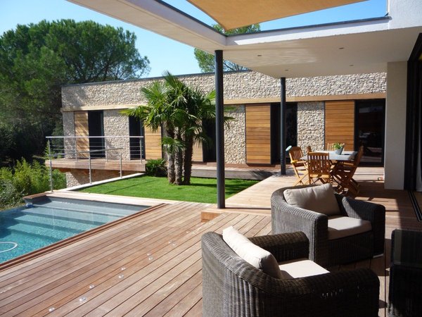 Comme le béton de bois sert de coffrage à la coulée du béton, il peut recevoir une finition intérieure et extérieure entièrement personnalisable, comme nous le prouve cette construction qui met en valeur le bois et la pierre.