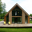 Construite en ossature bois, elle a été conçue pour disparaître dans le paysage, comme un bâtiment agricole et se distingue par un mur pignon fermé au nord et très ouvert au sud.