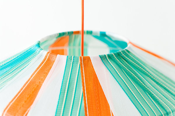 Les bandelettes de fauteuils de camping US sont cousues une à une sur la carcasse pour former un joyeux lampion bayadère.