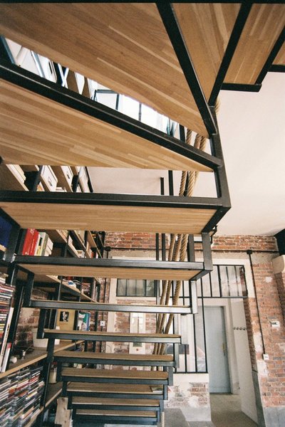 Un escalier en bois et acier, aux marches ajourées, permet d’accéder au second niveau qui accueillent chambres et salles de bains.
