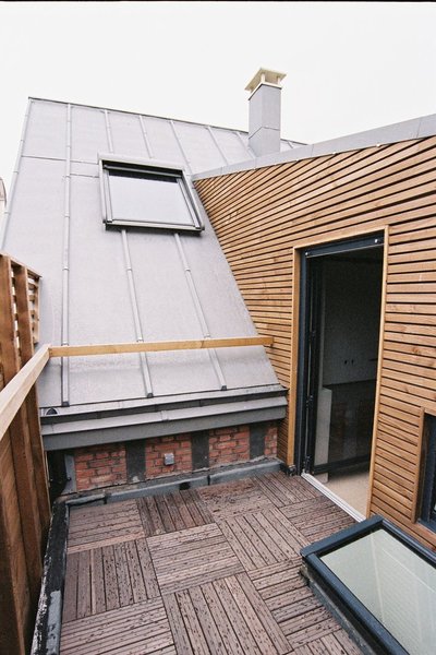 Au-dessus de la cuisine, la terrasse qui jouxte la chambre des parents, un volume rapporté recouvert d’un bardage en bois laisse apparaître la toiture en zinc de l’atelier d’origine, en venant s’emboîter dans son dessin en pente.