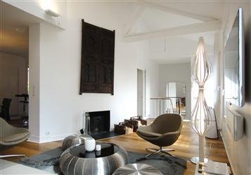 Un salon résolument contemporain avec des matériaux qui dessine un camaïeu de gris et de beiges. Tables basses, Roche-Bobois.