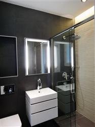 Pour les enfants et les invités, une salle de bains aménagée avec des éléments compacts gain de place et une recherche d’éclairages fonctionnels et parfaitement sécurisés (Réalisation Bain Douch Création).