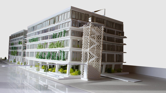 Un entrepôt sur le canal de l’Ourcq à Paris avec un espace autour réaménagé en parc végétal.