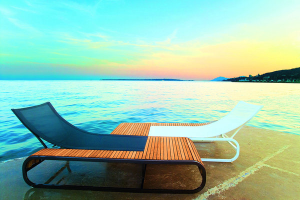 TANDEM – EGO. Bain de soleil du designer Thomas Sauvage. Dossier réglable 4 positions, sur roulettes.En Teck - Cannage Batyline® imputrescible, traité anti-UV (fils polyester gainés 100% PVC) - Structure en aluminium recouvert d'une laque argent haute résistance aux UV et aux intempéries. Dimensions : P 209 x Larg. 90 dont assise 60 x H 34/50/63/74 cm. Large gamme de coloris pour la toile et la structure.