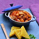 Parfumés et rustiques, les haricots Tarbais cuisinés à la tomate, au romarin, à la polenta et avec des rondelles de saucisse constituent un plat unique fameux et bon marché.