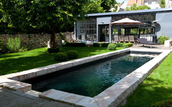 Environnez de verdure votre piscine, avec des bosquets et du gazon par exemple, pour un côté très nature.