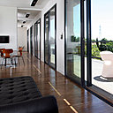 Un couloir de 1,50 m de large offre un dégagement qui s’inscrit dans la ligne de la terrasse qui borde deux côtés de la maison, au sud et à l’ouest. L’ensemble peut être cloisonné à volonté grâce à des grandes parois coulissantes, comme une double peau intérieure.