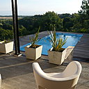 Coté ouest, la terrasse se prolonge, en contrebas, par une piscine en pleine nature. Fauteuils, création Ron Arad.