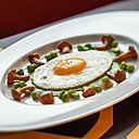 L’œuf au plat s’allonge en ce début d’automne sur une crème de petit pois au lard fumé, entouré de quelques girolles de saison.