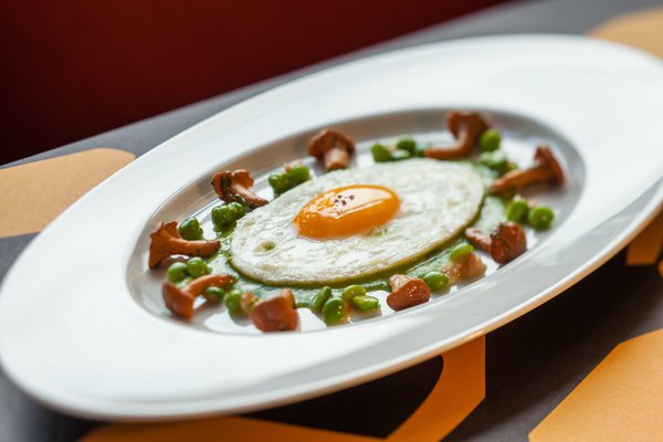 L’œuf au plat s’allonge en ce début d’automne sur une crème de petit pois au lard fumé, entouré de quelques girolles de saison.
