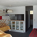 Avant les travaux, une cuisine mi-ouverte, mi-fermée attenante au séjour-salon. Ambiance "Bronzés font du ski"...