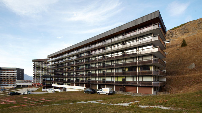 Au pied des pistes des Ménuires , un immeuble, en forme de barre, typique des stations de ski des années 1960. Au pied des pistes des Ménuires , un immeuble, en forme de barre, typique des stations de ski des années 1960.