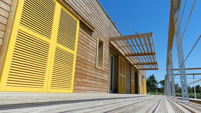 Élégance des volets jaunes répondant au bois naturel pour la sélection du Jury: maison "Ossard", catégorie Logements individuels plus de 120 m².