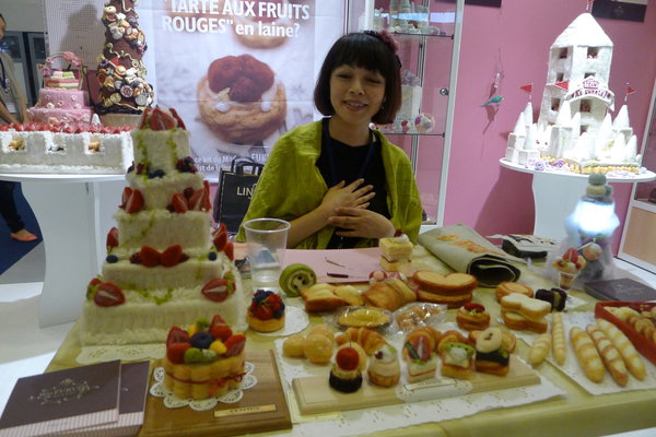 Rio Fukuda devant sa table de fabrication au salon l'Aiguille en Fête.