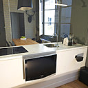 Derrière le bloc de la cuisine, côté chambre, la cloison en plaques de plâtre accueille un écran TV extra-plat. Au choix, on peut regarder la télé confortablement installé dans un modèle réédité de la Lounge Chair (création Ray et Charles Eames, chez Vitra) ou dans le lit.