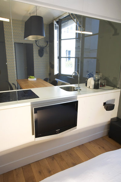 Derrière le bloc de la cuisine, côté chambre, la cloison en plaques de plâtre accueille un écran TV extra-plat. Au choix, on peut regarder la télé confortablement installé dans un modèle réédité de la Lounge Chair (création Ray et Charles Eames, chez Vitra) ou dans le lit.