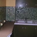 L’ancienne cuisine, au carrelage similaire à celui de la salle de bains, et aux couleurs typiques de la fin des années 1970.